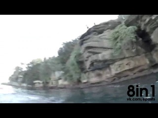 the guy jumps from a cliff into the water and collides with a shark